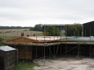 Stable roof showing the membrane being added to the roof